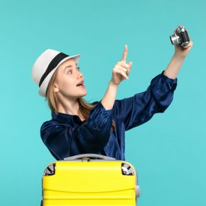 front-view-young-woman-taking-photos-with-camera-blue-background-woman-journey-sea-voyage-plane